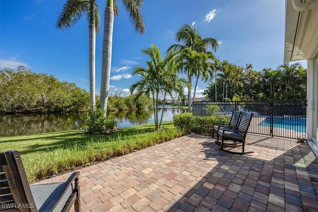 view of patio / terrace featuring a water view and a fenced in pool