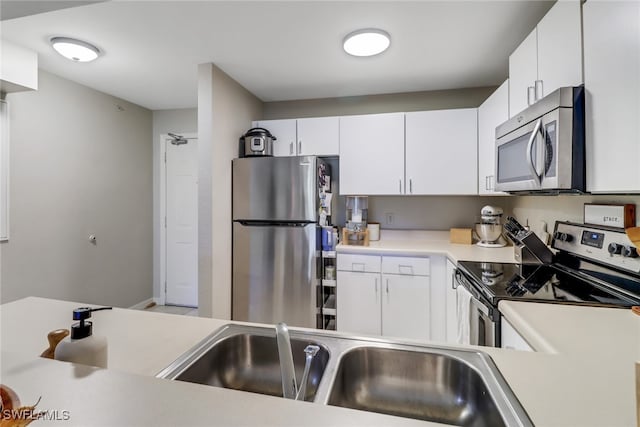 kitchen with appliances with stainless steel finishes, white cabinets, and sink