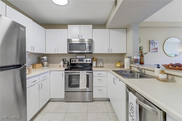 kitchen featuring sink, white cabinets, stainless steel appliances, and light tile patterned floors