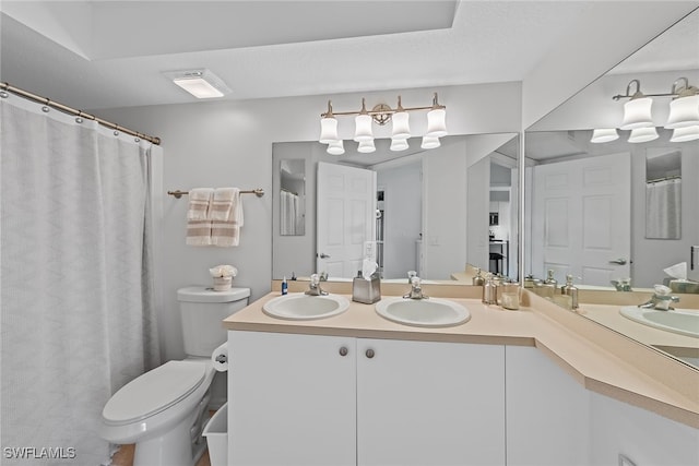 bathroom featuring vanity, a textured ceiling, and toilet