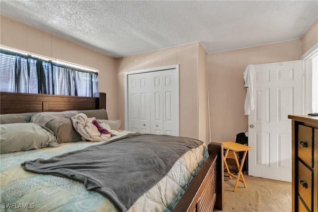 carpeted bedroom with a textured ceiling and a closet