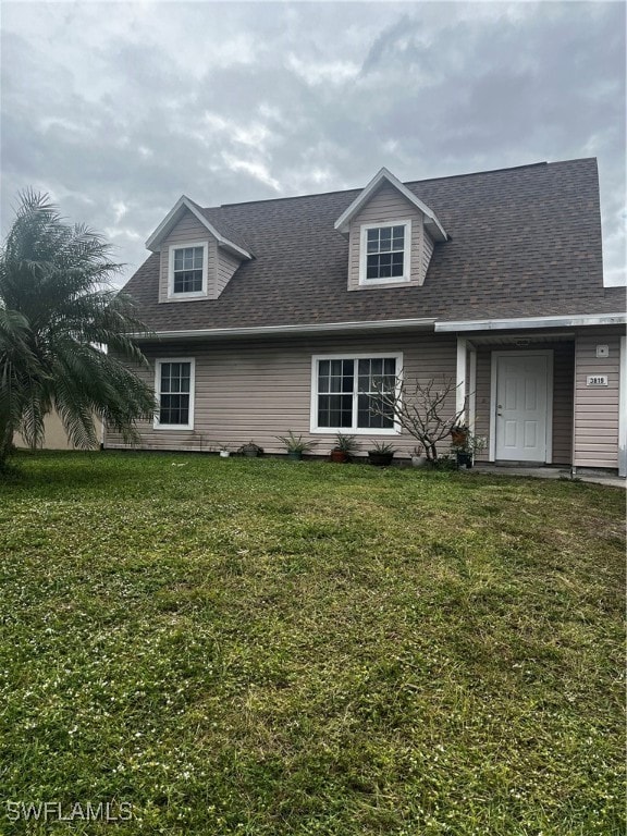 cape cod house with a front yard