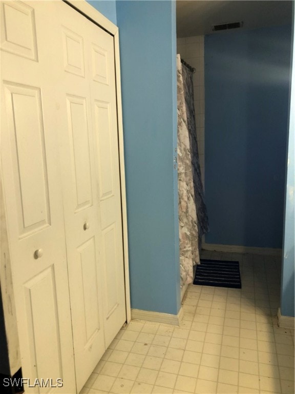 interior space with tile patterned floors and a shower with curtain