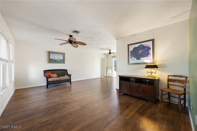 living area featuring dark wood-type flooring and ceiling fan