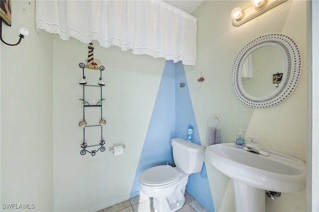 bathroom featuring toilet, tile patterned floors, and sink