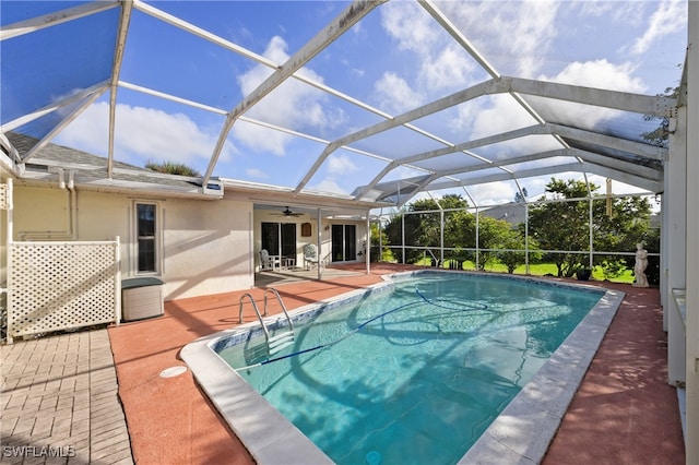 view of swimming pool featuring a patio area, a lanai, and ceiling fan