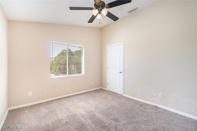 empty room featuring lofted ceiling, carpet, and ceiling fan