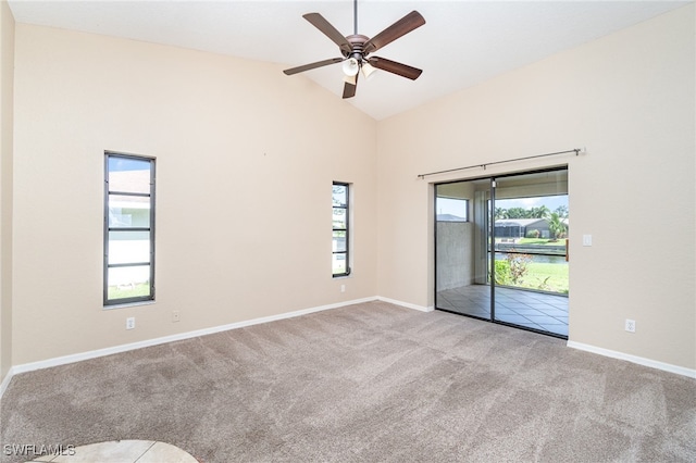 carpeted empty room featuring ceiling fan, high vaulted ceiling, and plenty of natural light