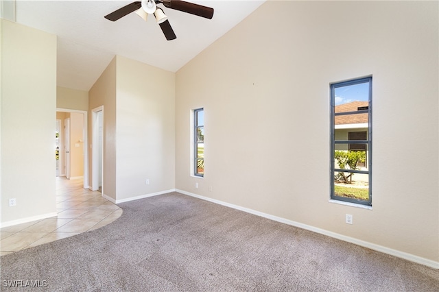 spare room with light carpet, high vaulted ceiling, and ceiling fan