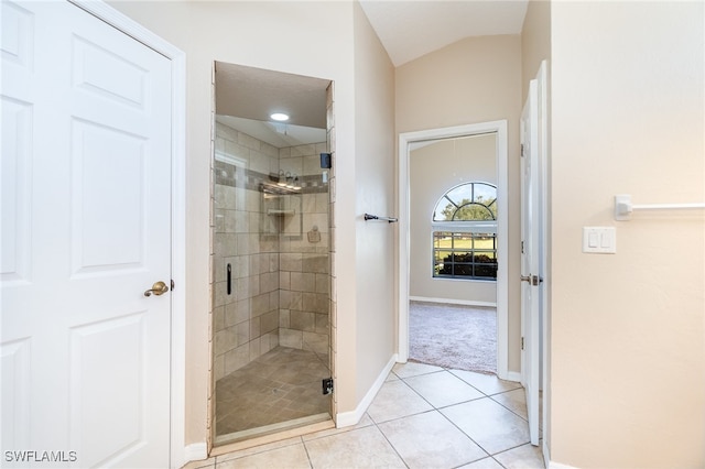 bathroom with tile patterned floors, vaulted ceiling, and walk in shower