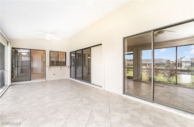 unfurnished sunroom with a water view and ceiling fan