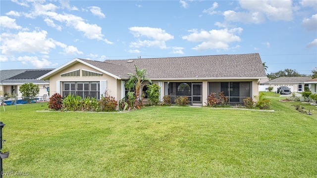 view of front of property featuring a sunroom and a front lawn