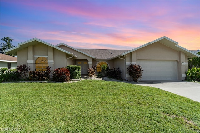 ranch-style home featuring a yard and a garage