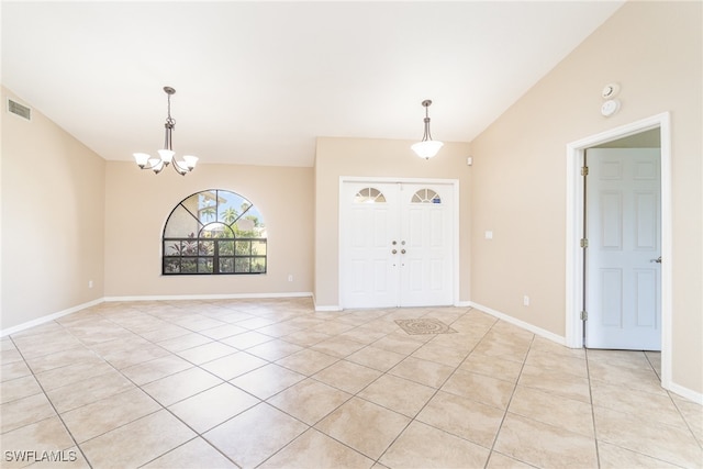 tiled foyer entrance with a chandelier and vaulted ceiling