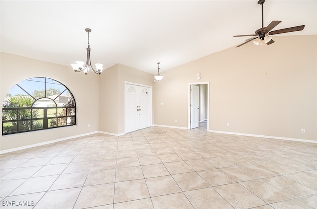 tiled spare room with lofted ceiling and ceiling fan with notable chandelier