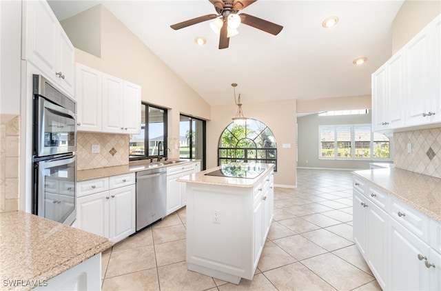 kitchen featuring decorative backsplash, white cabinets, hanging light fixtures, and stainless steel appliances