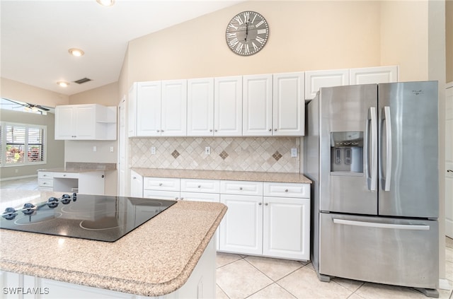 kitchen featuring black electric stovetop, white cabinetry, stainless steel refrigerator with ice dispenser, and backsplash