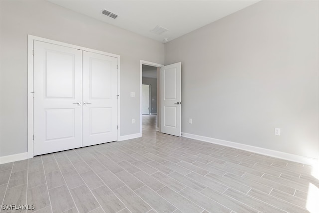 unfurnished bedroom with light hardwood / wood-style floors and a closet