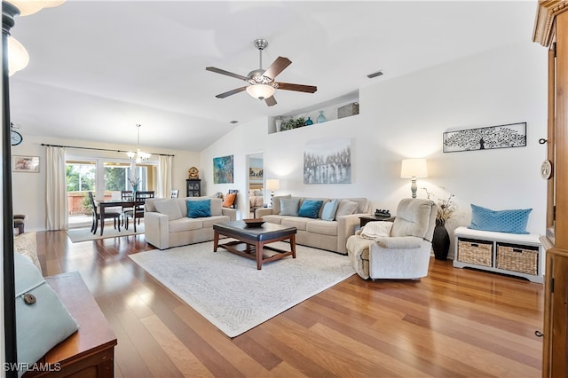 living room with vaulted ceiling, hardwood / wood-style flooring, and ceiling fan with notable chandelier