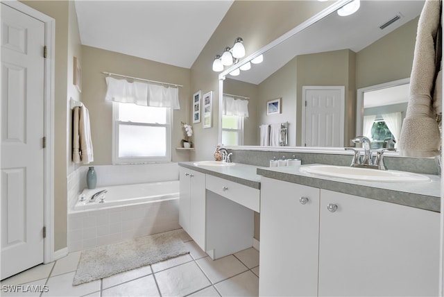 bathroom with vanity, lofted ceiling, a healthy amount of sunlight, and tiled bath