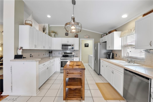 kitchen with decorative backsplash, white cabinets, appliances with stainless steel finishes, sink, and decorative light fixtures