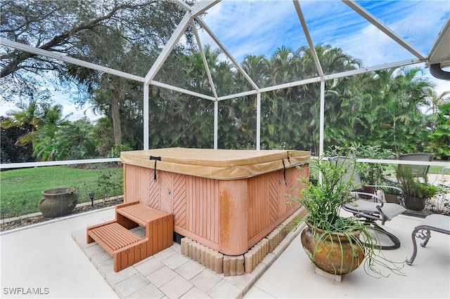 view of patio / terrace featuring a hot tub and glass enclosure