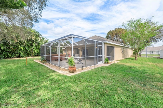 rear view of house featuring a yard, a patio, and a lanai