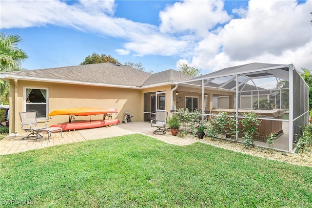 rear view of property with a patio, ceiling fan, a yard, and glass enclosure