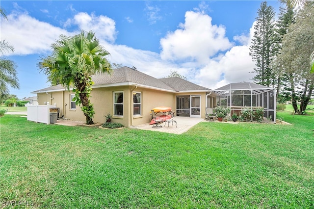 back of house featuring a patio, a lanai, and a yard