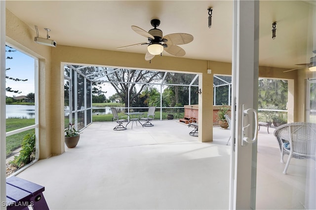 sunroom / solarium with a water view and ceiling fan