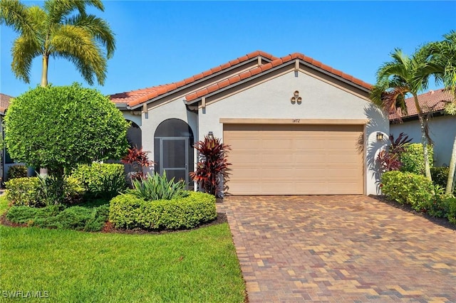 mediterranean / spanish-style house featuring a front lawn and a garage