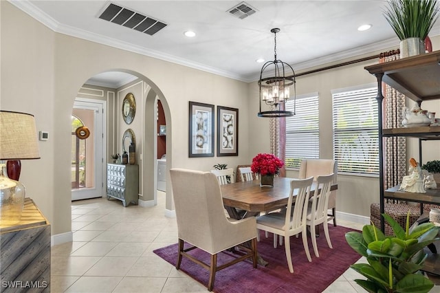 dining space with an inviting chandelier, ornamental molding, and light tile patterned floors