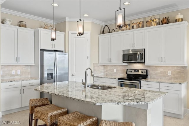 kitchen with white cabinets, appliances with stainless steel finishes, a kitchen breakfast bar, and sink