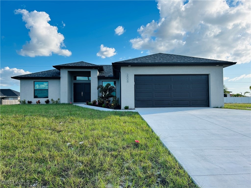 view of front of property featuring a front lawn and a garage