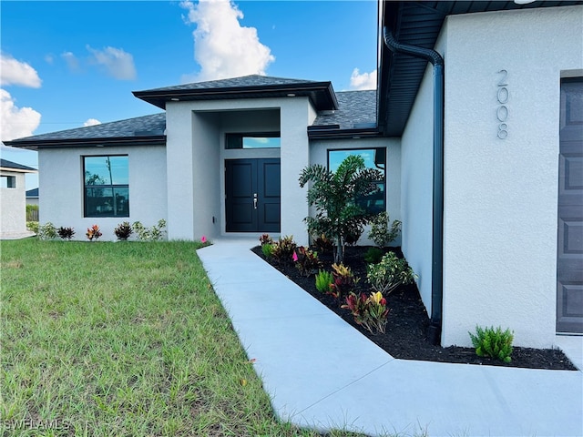 doorway to property with a lawn