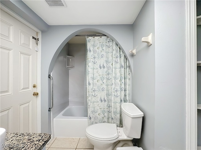 bathroom featuring tile patterned flooring, shower / tub combo with curtain, and toilet