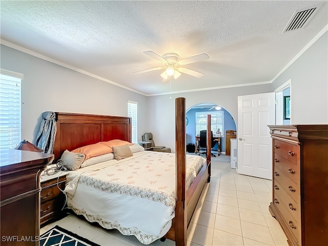 tiled bedroom featuring a textured ceiling, ceiling fan, and crown molding