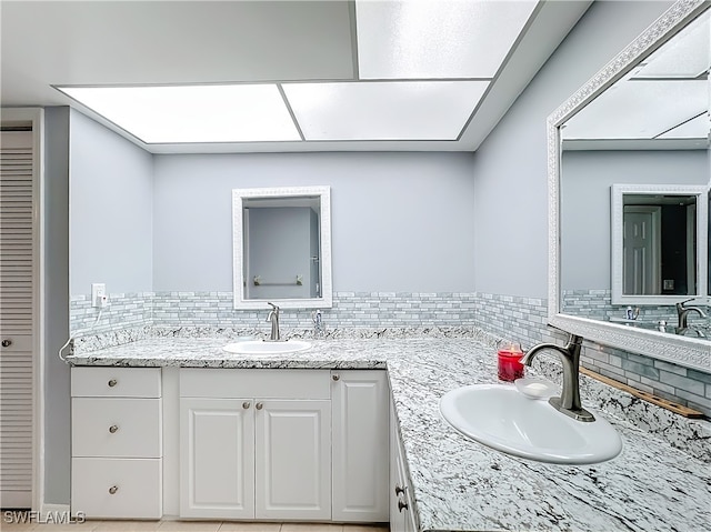 bathroom featuring a skylight, decorative backsplash, and vanity