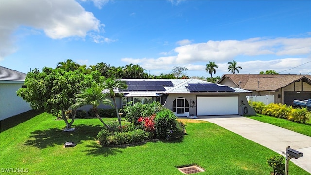 ranch-style home featuring a front yard, solar panels, and a garage