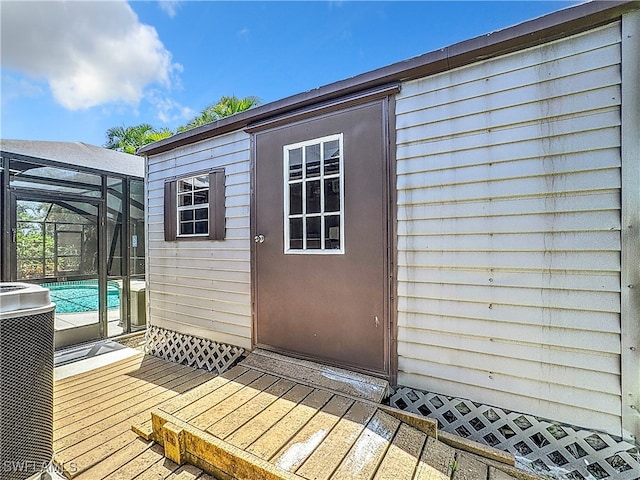 property entrance with central AC unit and a pool side deck