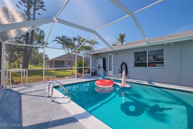 view of swimming pool featuring a patio area, a lawn, and glass enclosure