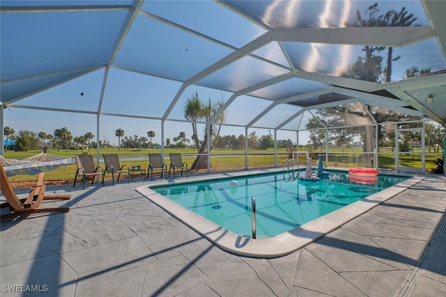 view of swimming pool with a jacuzzi, a patio area, a lawn, and a lanai