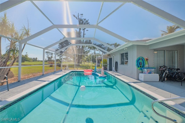 view of pool featuring a patio, a lawn, and glass enclosure