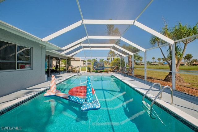 view of swimming pool featuring a patio, a lanai, and a lawn