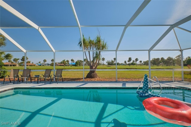 view of pool with a yard, a patio, and a lanai