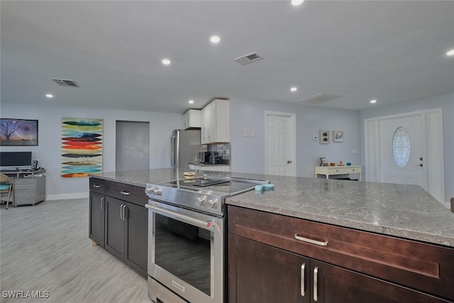 kitchen featuring appliances with stainless steel finishes, white cabinetry, light stone countertops, and dark brown cabinets