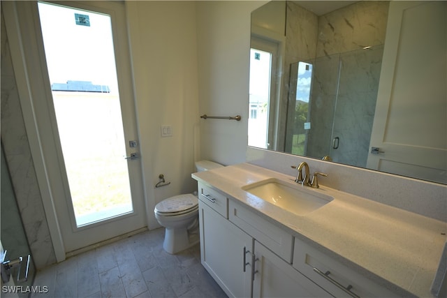 bathroom with toilet, a shower with shower door, and vanity