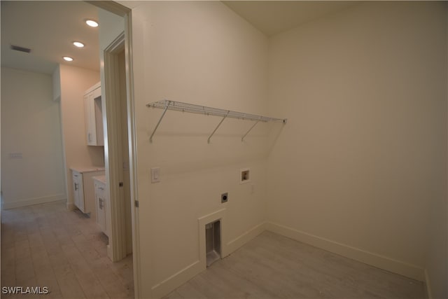 washroom with hookup for an electric dryer, washer hookup, and light wood-type flooring