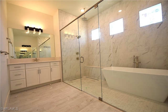 bathroom with vanity, a healthy amount of sunlight, hardwood / wood-style flooring, and plus walk in shower