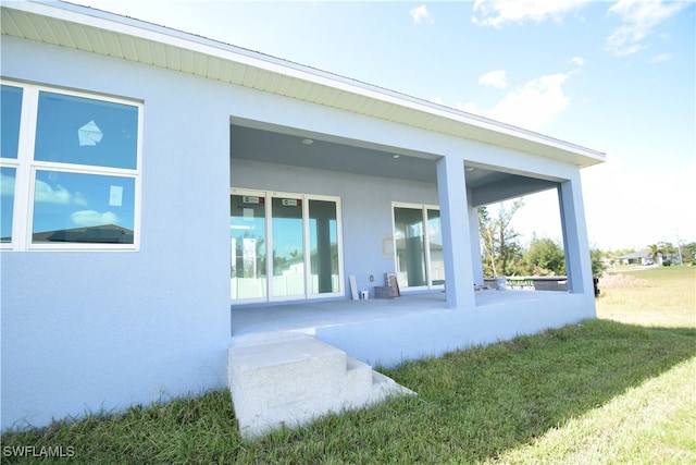 back of property with a patio area and a lawn